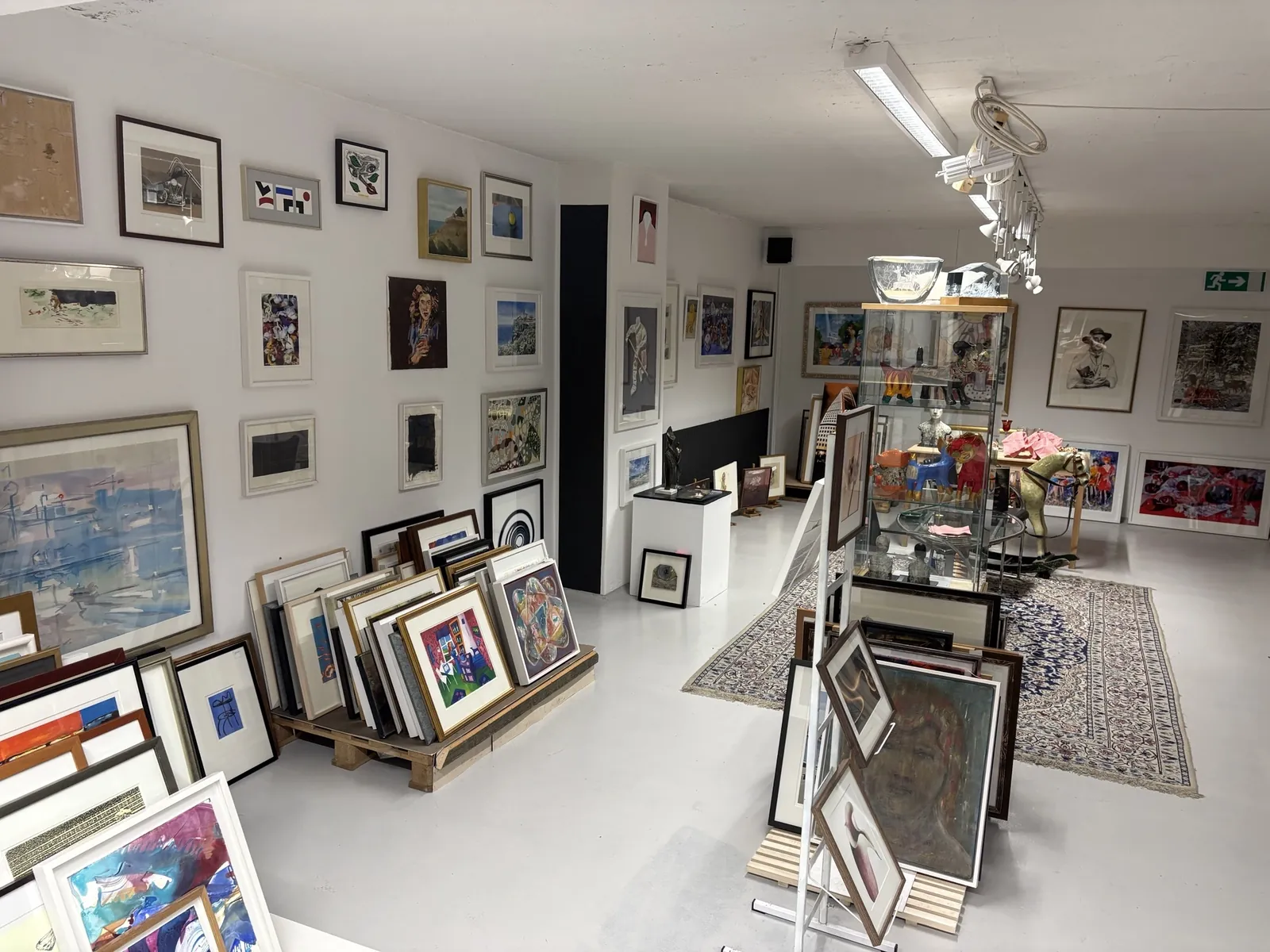 Interiör från galleriet med ett urval av konstverk och ramar